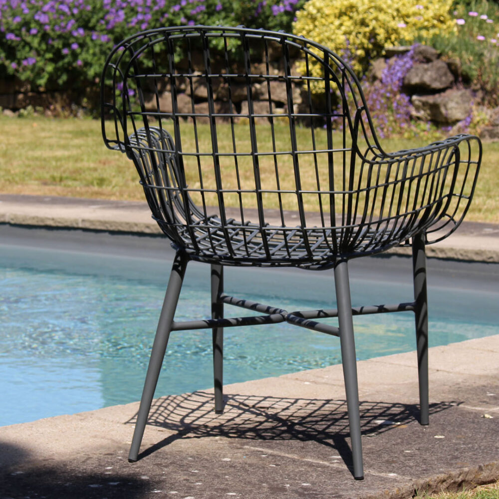 Rear view of the Tunis chair in graphite in front of an outdoor pool.