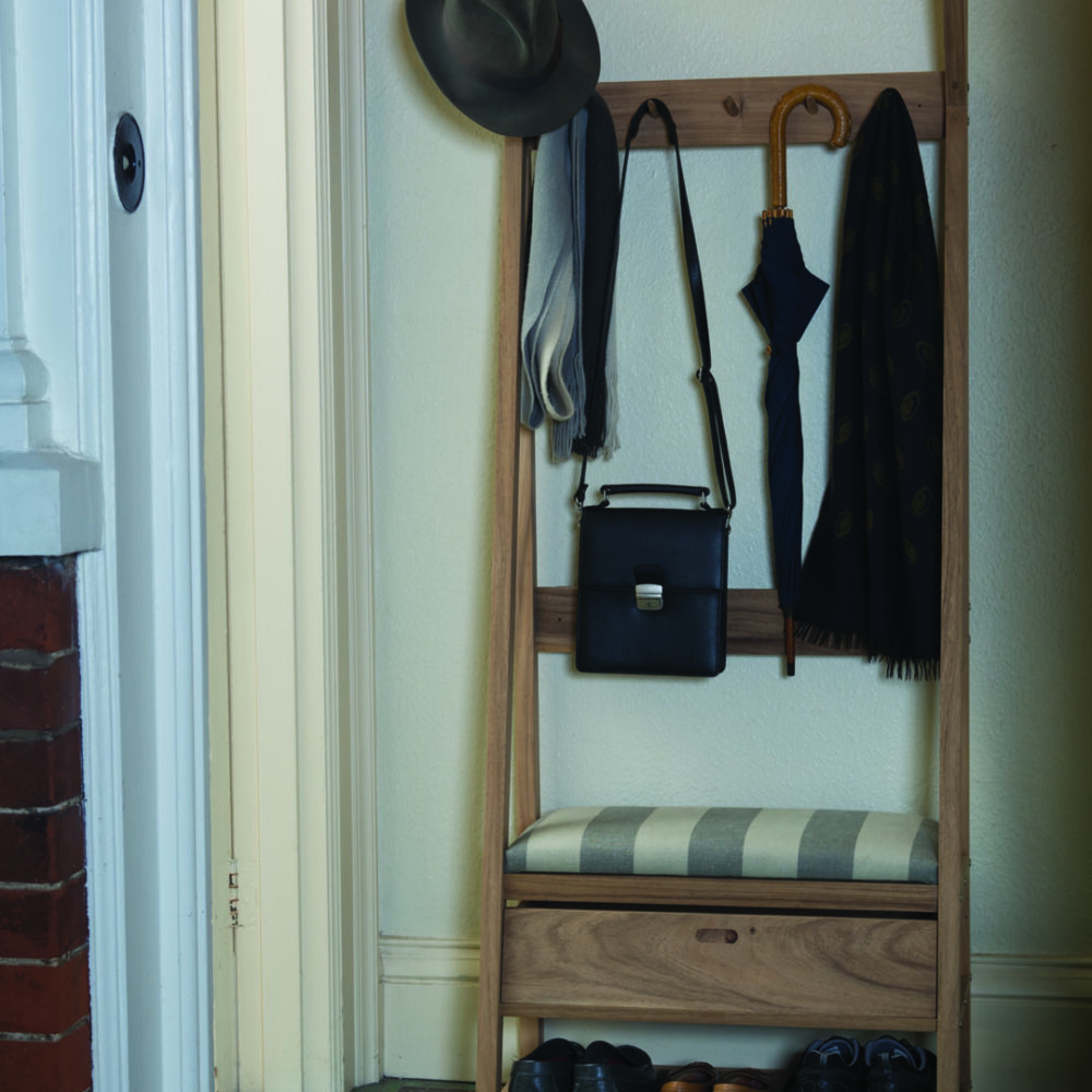 An welcoming open door shows a Totem hall stand with shoes, coats and accessories on it.