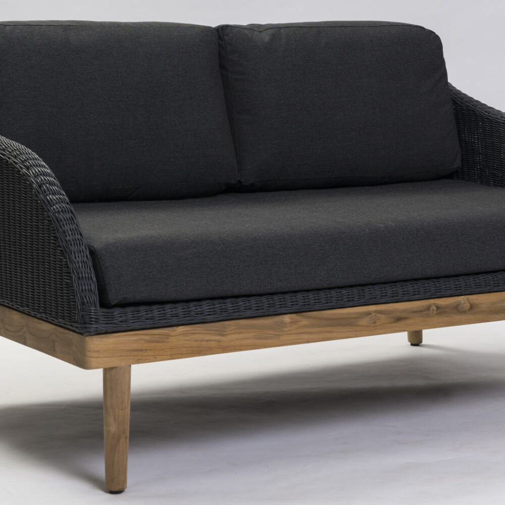 A studio shot of the Harris outdoor sofa in slate and teak with charcoal pads in outdoor fabric.